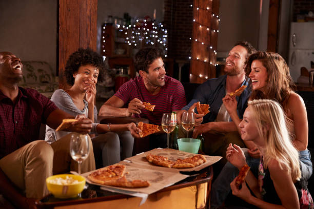 jeunes adultes partageant des pizzas à une partie à la maison - box lunch photos et images de collection