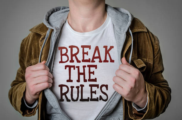 Man showing Break the rules tittle on t-shirt Man showing Break the rules tittle on t-shirt. Positive attitude and success concept. graphic t shirt stock pictures, royalty-free photos & images