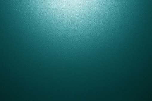 photograph of turquoise blue background with sparkle texture, halo style vignette lighting and copy space
