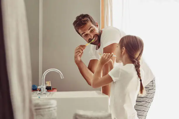 Shot of a happy father and his little girl washing their hands together in the bathroom