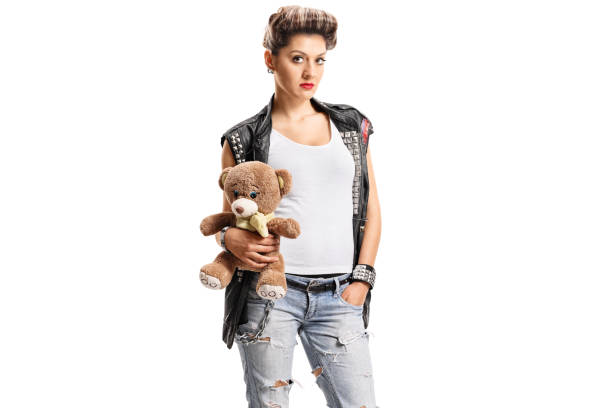 Punk girl holding a teddy bear isolated on white background