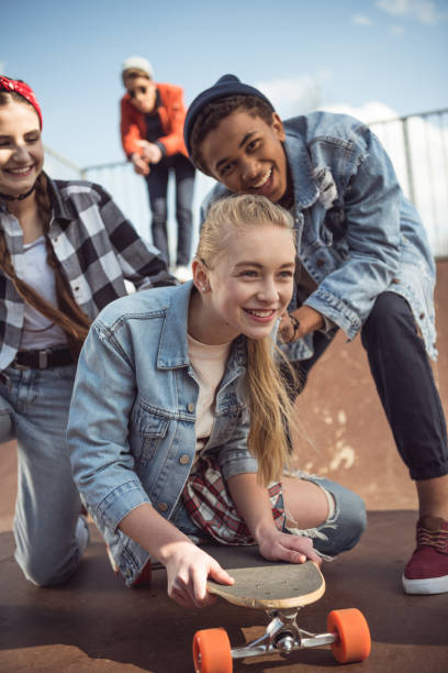 istock friends helping girl riding skateboard 684055754