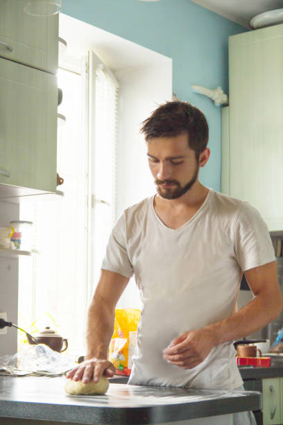 o homem amassa a massa na cozinha - bread kneading making human hand - fotografias e filmes do acervo