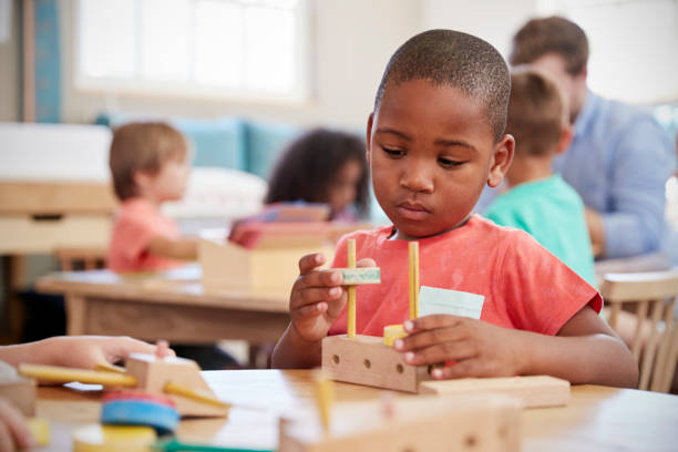 木製の形の机で働くモンテッソーリの瞳 - african ethnicity student child group of people ストックフォトと画像