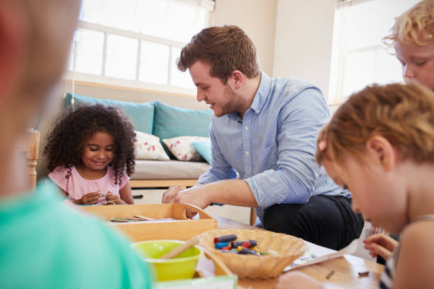 istock Teacher And Pupils Working At Tables In Montessori School 684057410