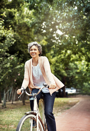 Shot of a mature woman enjoying a bike ride in the park