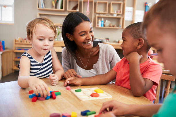 lehrer und schüler mit holzformen in montessori-schule - kind im grundschulalter stock-fotos und bilder