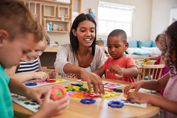 lehrer und schüler nutzen blumenformen in montessori-schule - lehrtaetigkeit stock-fotos und bilder