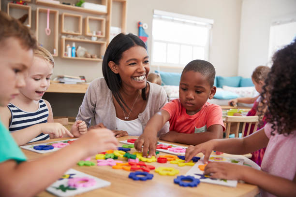 istock Teacher And Pupils Using Flower Shapes In Montessori School 684061674