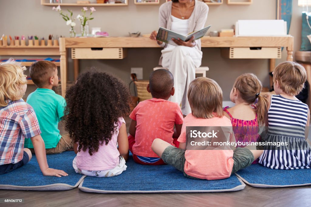 Enseignant en école Montessori lecture aux enfants à l’heure du conte - Photo de Maternelle libre de droits