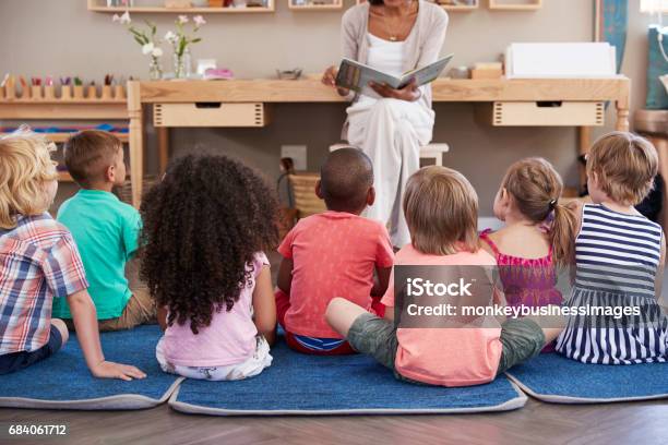 Photo libre de droit de Enseignant En École Montessori Lecture Aux Enfants À Lheure Du Conte banque d'images et plus d'images libres de droit de Maternelle