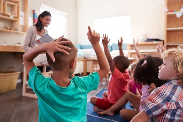 istock Pupils At Montessori School Raising Hands To Answer Question 684061888
