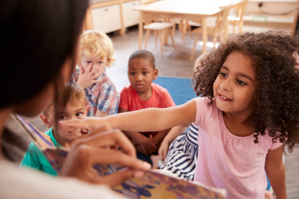 先生の本を見てモンテッソーリ校生徒 - african ethnicity student child group of people ストックフォトと画像