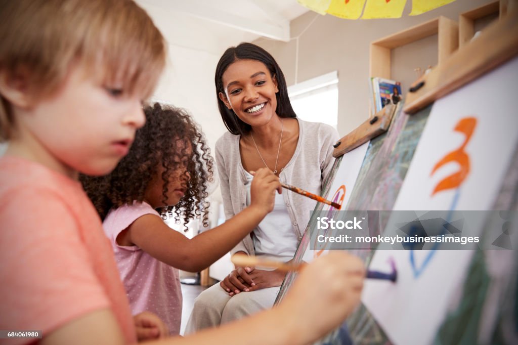 Teacher At Montessori School Helping Children in Art Class Teacher Stock Photo