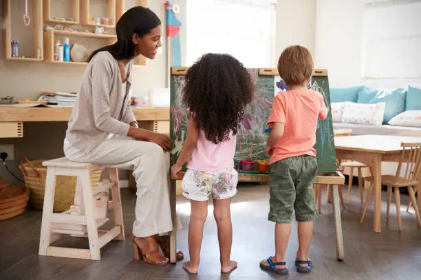 Photo of Teacher At Montessori School Helping Children in Art Class