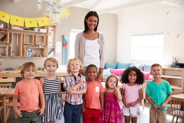 Portrait Of Teacher With Pupils In Montessori School Classroom Portrait Of Teacher With Pupils In Montessori School Classroom preschool age photos stock pictures, royalty-free photos & images