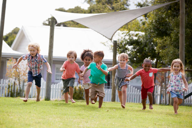 間に屋外の楽しい時を過すモンテッソーリ学校で子供を破る - preschool child preschooler multi ethnic group ストックフォトと画像