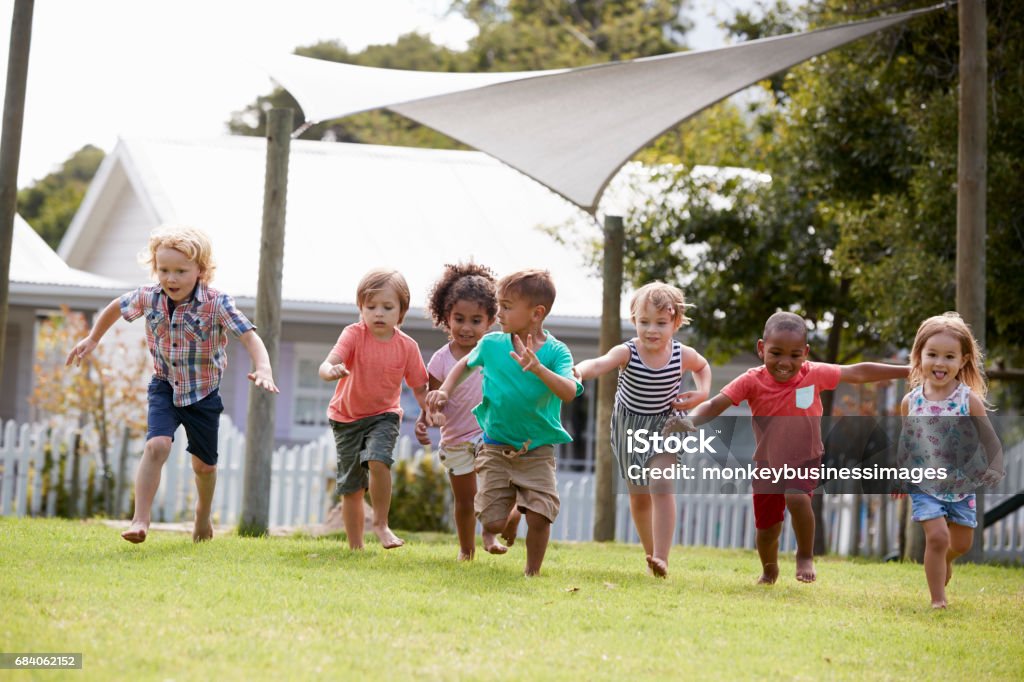 Children At Montessori School Having Fun Outdoors During Break Outdoors Stock Photo