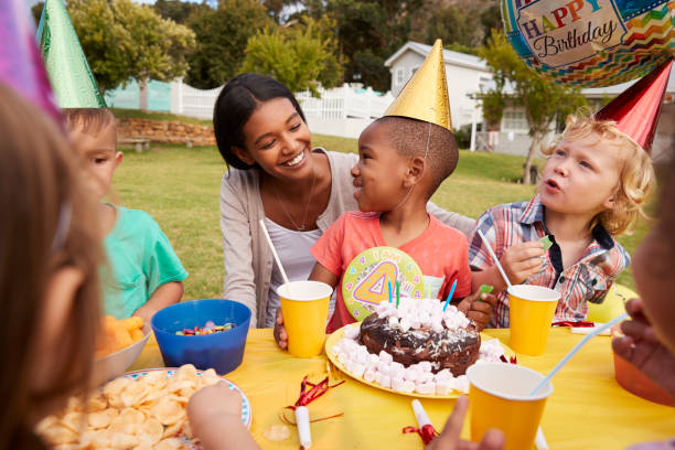 madre con bambini che si godono la festa di compleanno all'aperto insieme - birthday family party cake foto e immagini stock
