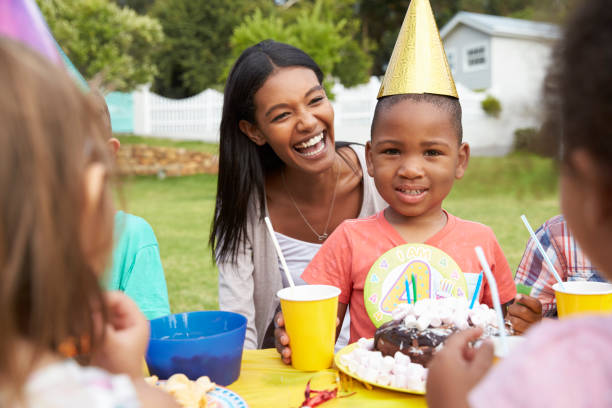 一緒に屋外の誕生日パーティーを楽しむ子供を持つ母親 - group of people people family multi ethnic group ストックフォトと画像