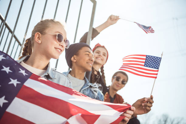 istock teenagers waving american flags at sunset 684062736