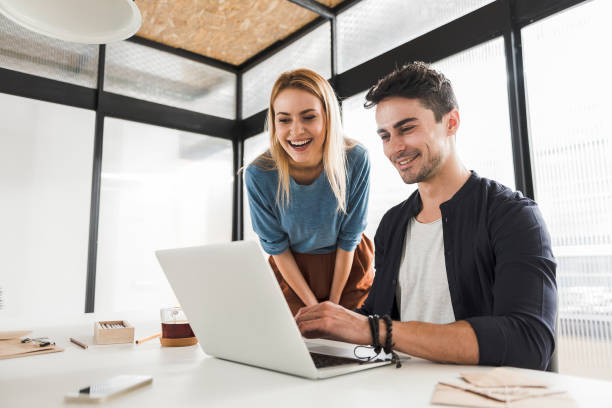 happy smiling office workers in bureau - using laptop contemplation accessibility contemporary imagens e fotografias de stock