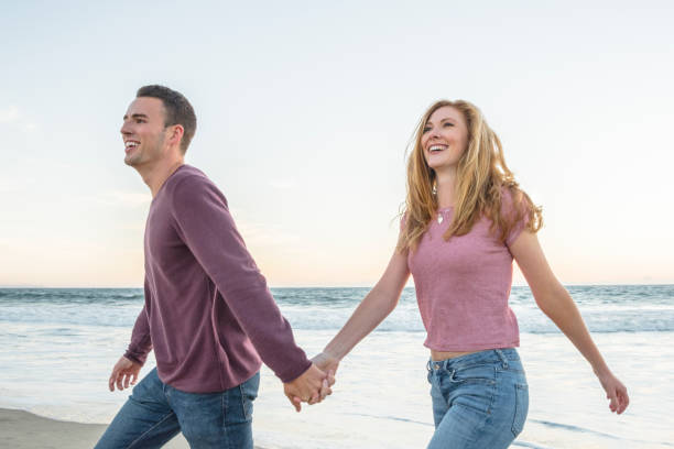 istock Young couple holding hands on beach smiling 684071800