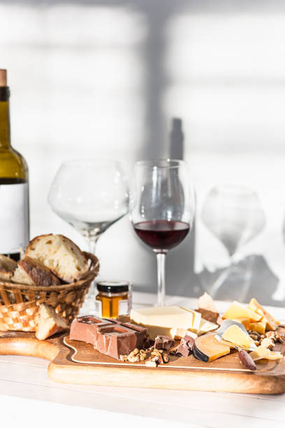 The red wine, baguette and cheese on wooden background