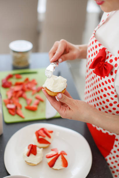 istock Smiling blonde woman cooking cupcakes in kitchen 684082698