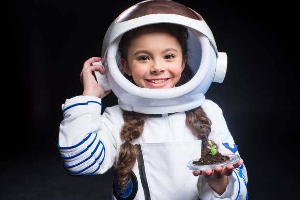 istock Girl astronaut holding plant 684083238