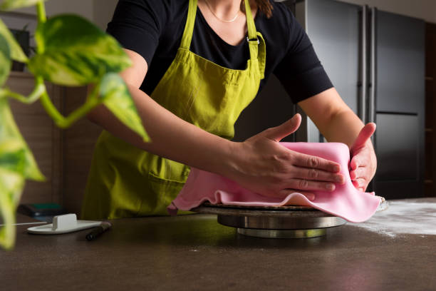 istock Woman in bakery decorating heart shaped cake with royal icing 684098188