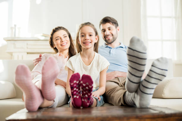 istock smiling daughter sitting with hugging parents on sofa at home 684098604