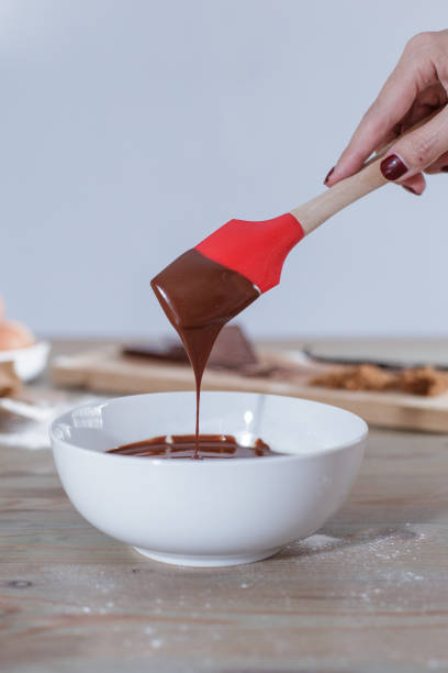istock Woman's hand folding brownie mix in a white bowl 684098696