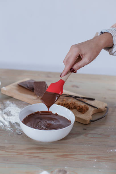 istock Woman's hand folding brownie mix in a white bowl 684098698