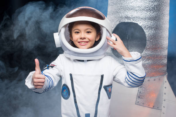 Girl in astronaut costume Cute little girl in astronaut costume showing thumb up and smiling at camera space and astronomy photos stock pictures, royalty-free photos & images
