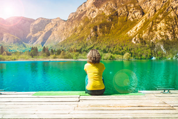 istock Woman relaxes on lake pier 684115126