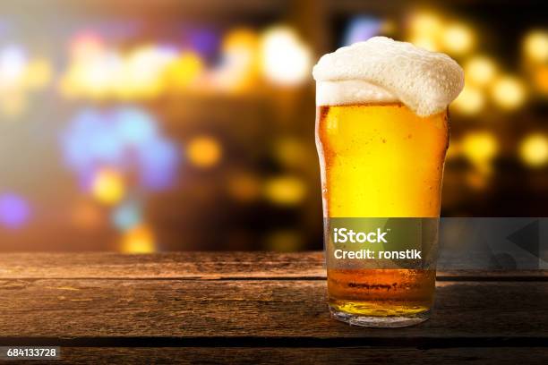 Glass Of Beer On A Table In A Bar On Blurred Bokeh Background Stock Photo - Download Image Now