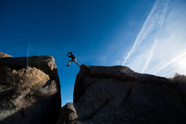istock Man leaping between boulders in the desert 684140132