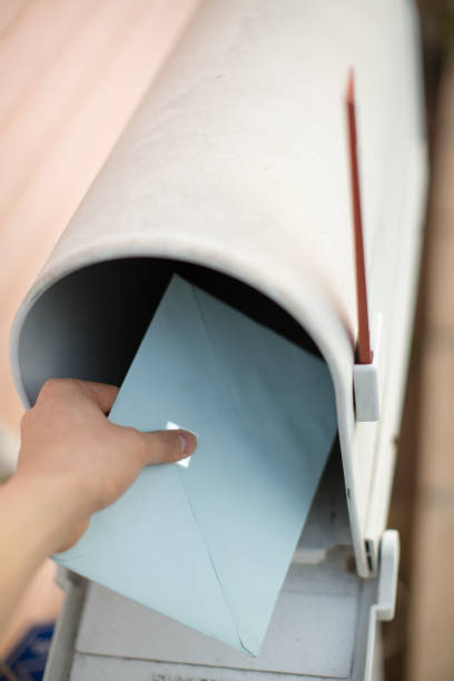 istock Person sending an envelope and putting in mailbox 684147990