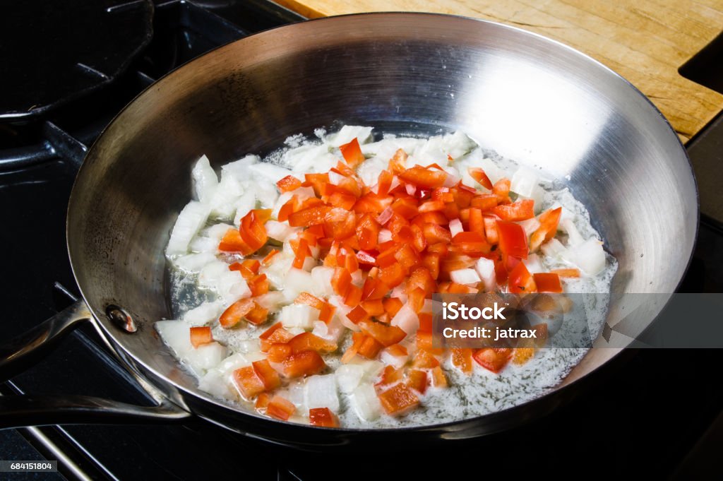 Red peppers and onions sauting in fry pan Red peppers and onions sauting in fry pan on the stove Appliance Stock Photo