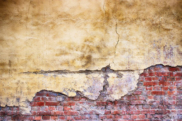 istock brick wall with damaged plaster, background shattered cement surface 684156378