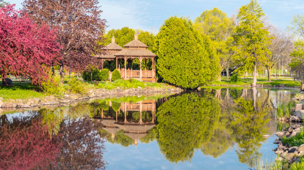 Flowering Trees and gazebos reflected in still waters.