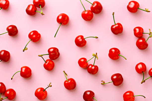 Cherry pattern. Flat lay of cherries on a pink background.Top view stock photo