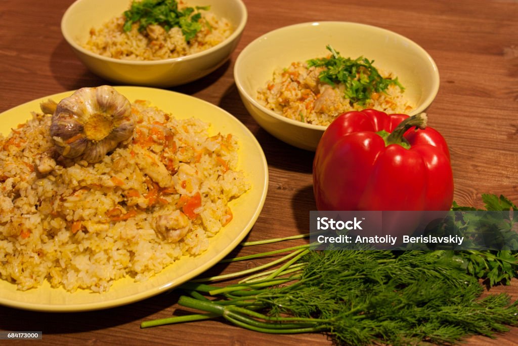 Pilaf on the clay plate on a wooden table. Pilaf on the clay plate on a wooden table. Background. Animal Stock Photo