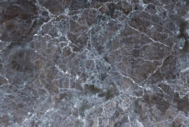 Photo of Black marble texture shot through with subtle white veining.
