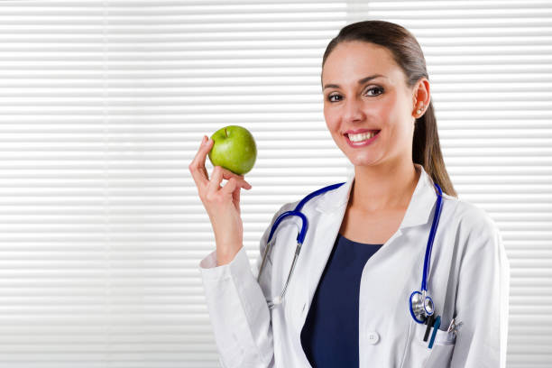 istock Female Nutritionist holding a green apple 684247868