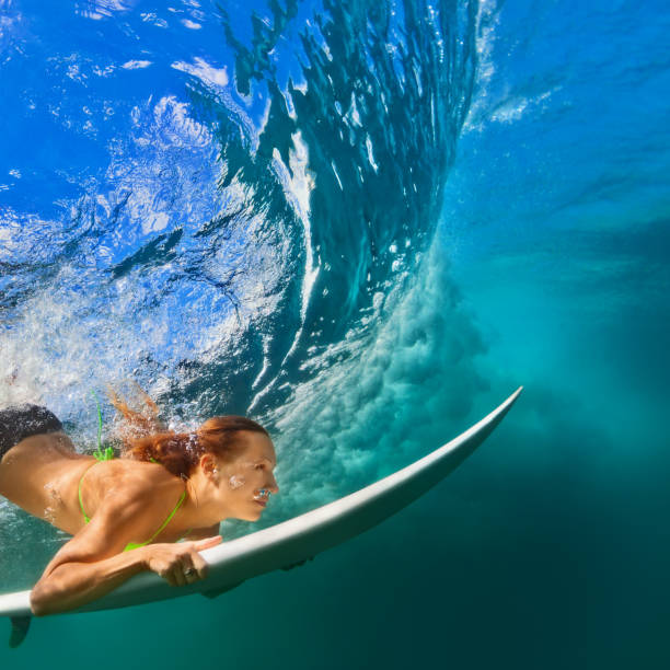 active girl in bikini in dive action on surf board - surfboard fin imagens e fotografias de stock