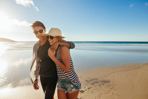 istock Happy couple walking on beach 684256670