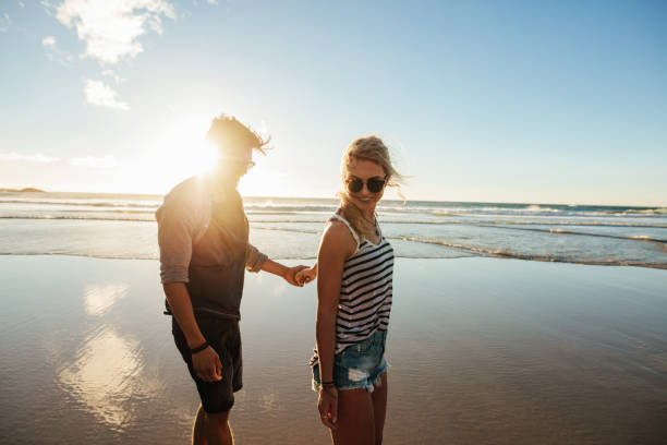 istock Romantic young couple walking along the sea shore 684256822