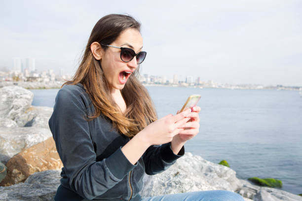 istock Surprised young woman using smart phone 684327938